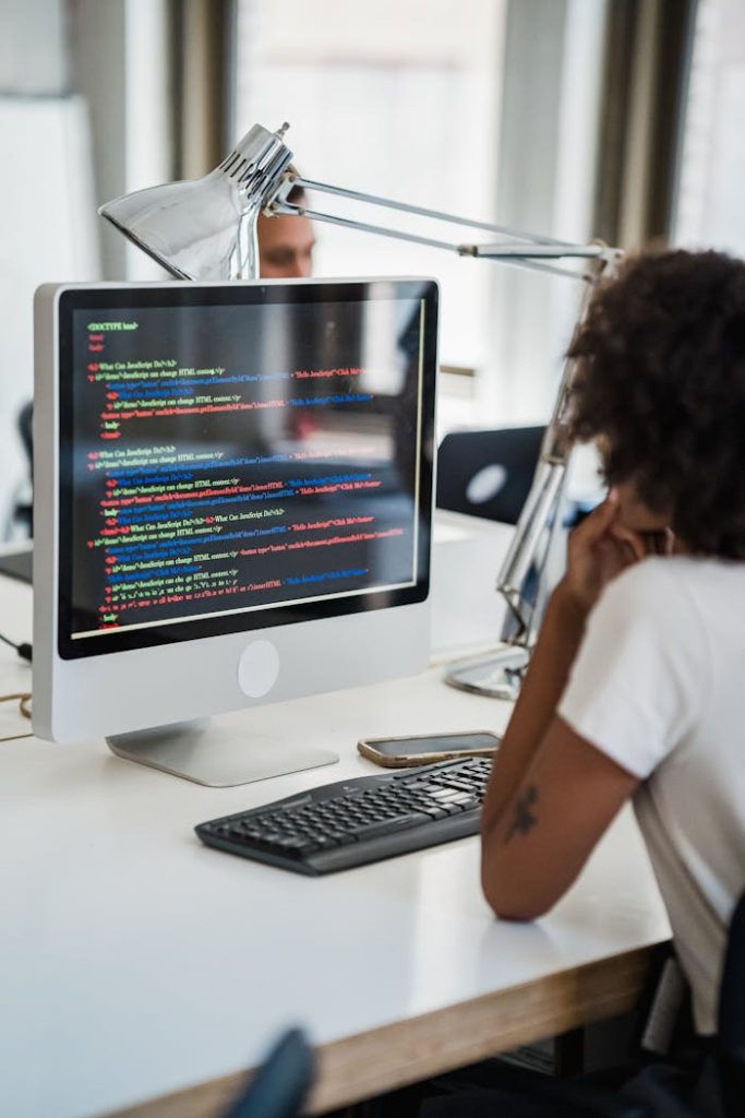 Crafting Captivating Headlines: Your awesome post title goes here A female professional focused on coding at her office desk with a desktop computer.