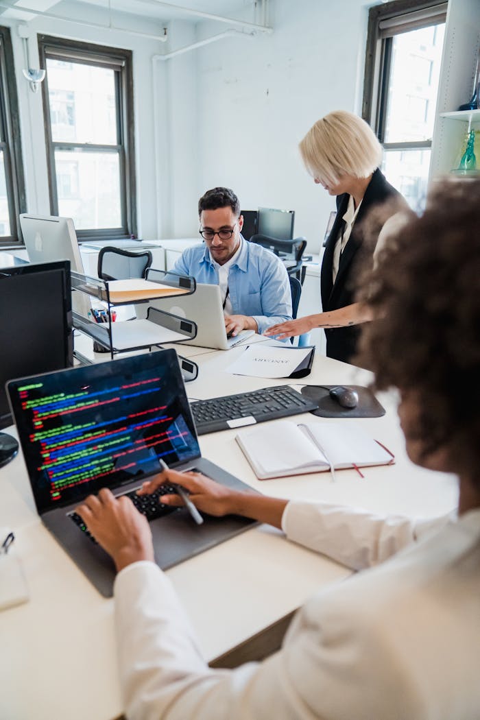 The Art of Drawing Readers In: Your attractive post title goes here Team of professionals collaborating in a modern office, focused on coding and project management.